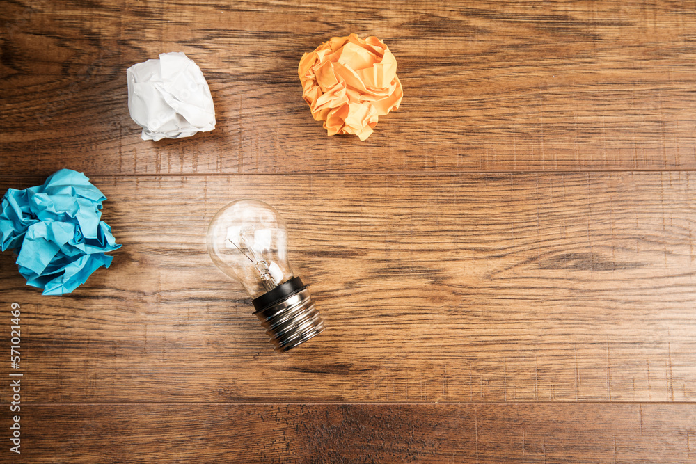 Wall mural Light bulb and crumpled papers