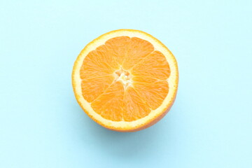 Half an orange isolated on light blue background