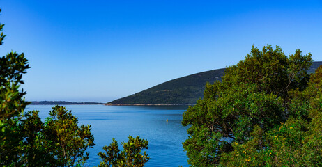 Fototapeta na wymiar stunning natural landscape and seascape in Herceg Novi Montenegro , sea, mountains, green forest rees, deep blue sky, beautiful horizon