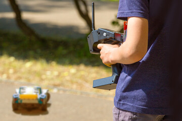 teen boy with electric remote control car toy play outdoor on sidewalk - obrazy, fototapety, plakaty