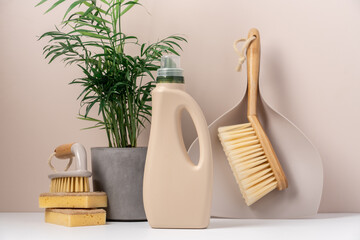 Set of eco-friendly cleaning tools on beige background with green plant. Concept of spring cleaning...