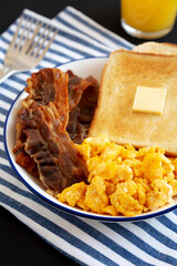Homemade American Scrambled Egg Breakfast on a Plate on a black background, side view. Close-up.