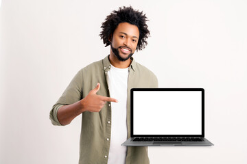 Satisfied african man advertising new computer app isolated on white background, mock-up. Positive...