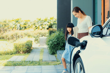 Focus electric vehicle recharging at home charging station plugged in with EV charger device with...