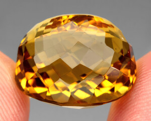Natural gemstone yellow citrine on gray background