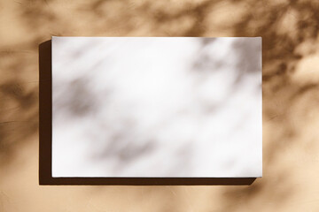 White canvas, blank picture mockup hanging on beige wall with dark shadows of leaves. Poster mockup, empty canvas with shadows of plant, front view