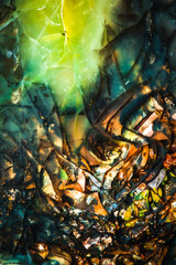 Opal (opalized petrified wood (fossilized opal)) blue yellow green orange macro detail texture background. close-up polished semi-precious gemstone.