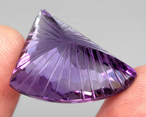 Natural gemstone purple amethyst on gray background