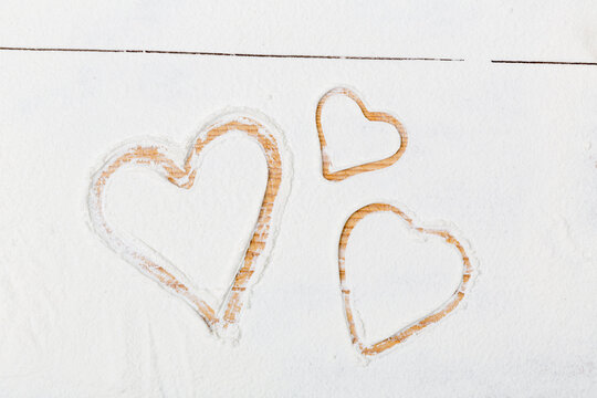 hearts painted in flour on a wooden ground