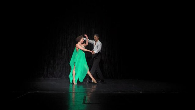 Ballroom pair performs rumba cucarachas element in closed, then Open Hip Twist to Fan, sequence several turns and spins. Side Walks at end