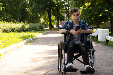 young disabled man in wheelchair walking park and listening music
