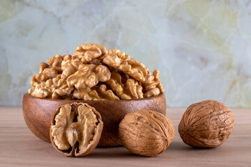 A bowl of peeled walnuts and a group of shelled walnuts