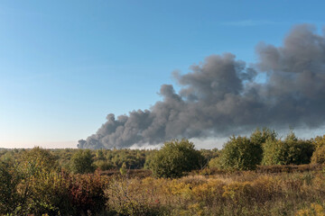 Obraz na płótnie Canvas A large black column of thick smoke is visible on the horizon