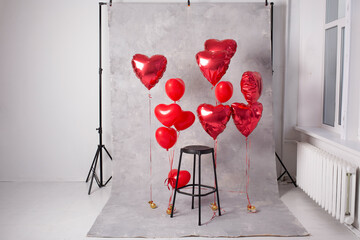 studio photo with chair zone with red heart-shaped balloons for valentine's day. Gray background. White background