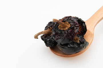 Cuchara de madera con pimientos secos para cocinar, aislados en blanco