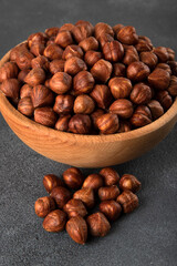 View of a bowl full of hazelnuts on a black background