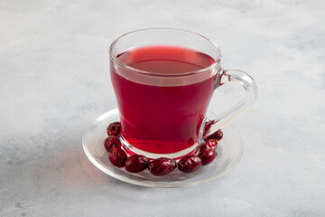 A glass of rose hip tea and rosehip seeds on bright background

