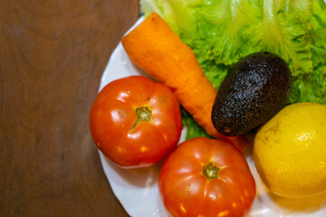 avocado, lettuce, tomato and carrot on a plate