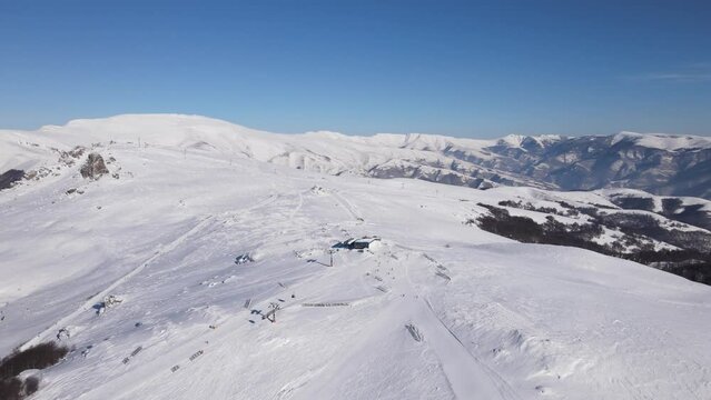 Skier on the ski slope piste downhill skiing in winter day on snow in Old Mountain Stara planina Babin Zub resort tourist destination drone aerial view
