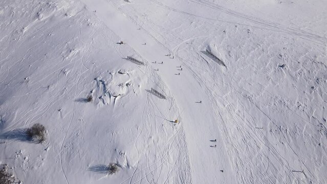 Skier on the ski slope piste downhill skiing in winter day on snow in Old Mountain Stara planina Babin Zub resort tourist destination drone aerial view