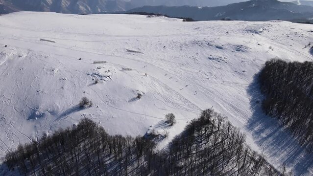 Skier on the ski slope piste downhill skiing in winter day on snow in Old Mountain Stara planina Babin Zub resort tourist destination drone aerial view