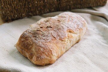freshly baked ciabatta. bread on the tablecloth. Home baked whole grain bread. Crusty sourdough loaf of wheat bread with wholegrain flour. fried bread crust.