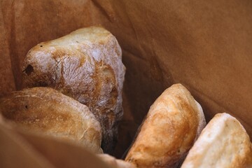 freshly baked bread in craft bags. Home baked whole grain bread. Crusty sourdough loaf of wheat bread with wholegrain flour.	