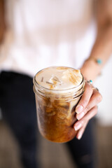 person holding a glass of iced coffee