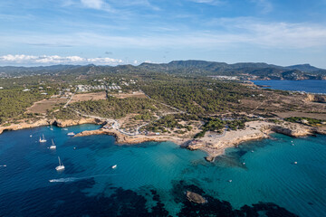 Obraz premium Aerial photographs of the beaches of Cala Conta and Cala Escondida, on the island of Ibiza during a sunny summer day with blue sky and turquoise water