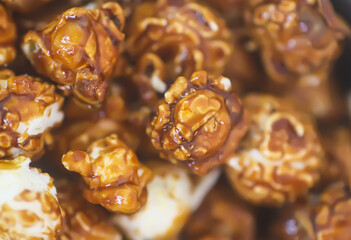 Sweet ready-to-eat popcorn in a black ceramic plate close up.