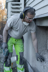 Man Inspecting Demolished Concrete Wall for Window Installation