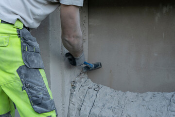 Man Demolishing Concrete Wall for Window Hole Creation.