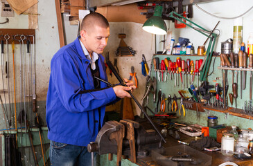 Lubricating and cleaning the barrel of rifle in a gun workshop