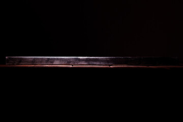 Side view of the canvas stretched on a stretcher. The concept of the modern school of art. Dark brown background. The work of art lies on a wooden table.
