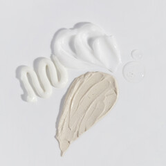 Composition of various cream, serum and mask smear on a white background. Beauty texture. Sample of a cosmetic product.