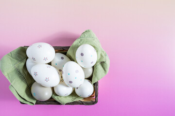 Decorated Easter eggs in a basket on a gradient background.
