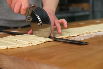 the process of making Grissini. grissini with olives and thyme recipe. cook cuts grissini. baker at work. The baker shapes the bread. Hands on the close-up foruyut bread