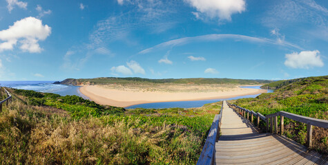 Atlantic ocean coast, wooden walkway to Amoreira beach and Aljezur river summer view, Algarve...