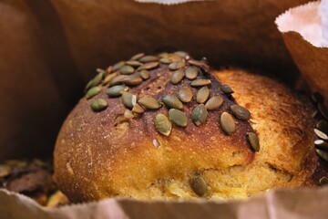 freshly baked bread in craft bags. Home baked whole grain bread. Crusty sourdough loaf of wheat bread with wholegrain flour.	