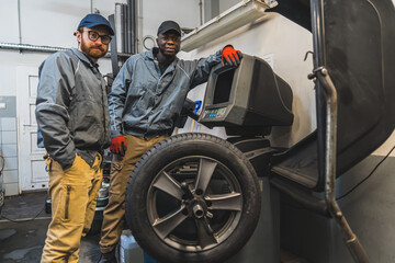 multiracial mechanics posing for a picture in a car repair shop, medium full shot. High quality photo