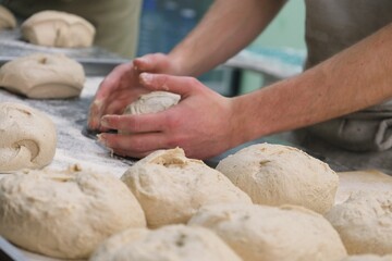 baker at work. The baker shapes the bread. Hands on the close-up form bread