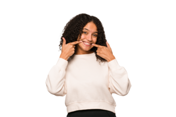 Young african american curly woman isolated smiles, pointing fingers at mouth.