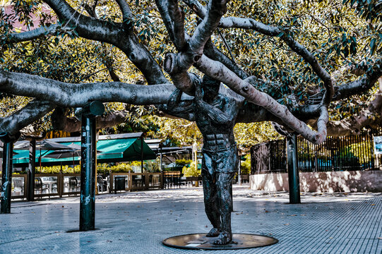 Buenos Aires, Argentina - December 21, 2022: Atlas of Recoleta (2014), by Uruguyan artist Joaquin Arbiza (b: 1993), a metal statue of Atlas lifting the Gomero de la Recoleta tree in the Recoleta distr