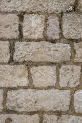 Fragment of a stone wall of an old house in the fortress of the city of Dubrovnik, Croatia.