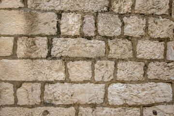 Fragment of a stone wall of an old house in the fortress of the city of Dubrovnik, Croatia.