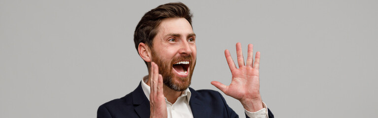 Positive businessman with a beard puts his hands to the side of his mouth and screams