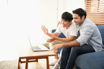 Obraz premium Couple young man sitting in the living room while doing internet facing with social network together.