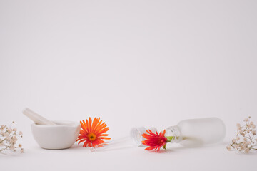 The glass skin care bottle with dropper, pestle, and mortar on white background with the copy space. Beauty and lifestyle background.