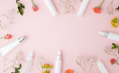 skincare and cosmetic product on pink pastel background with flower. Beauty and lifestyle concept with copy space, flatlay. 