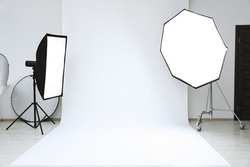 Interior of modern photo studio with professional lighting equipment - obrazy, fototapety, plakaty